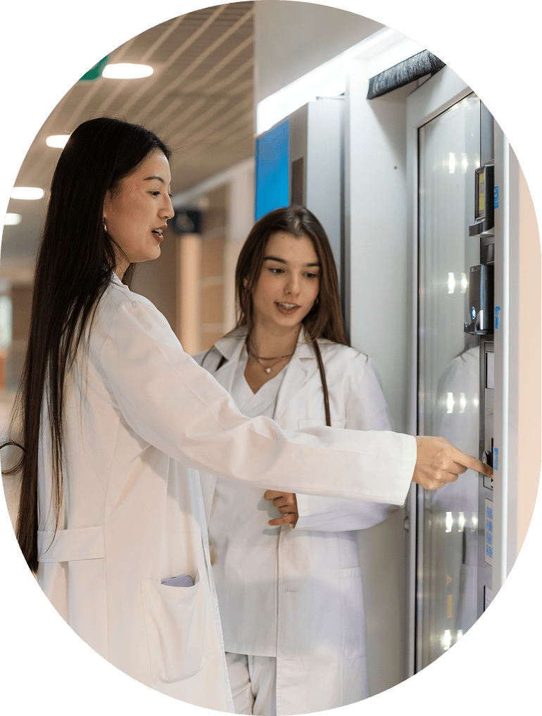 Two women in lab coats discussing device