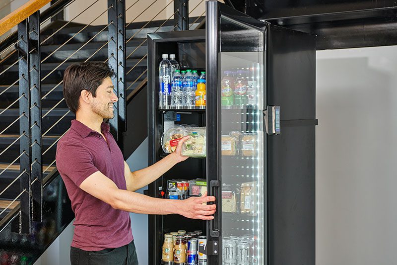 Person taking salad from office refrigerator